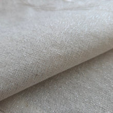 Zoomed in fabric detail, showing silver sparkle cross-threads on neutral white fabric.