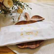 The Apple Challah Board is made from natural Acacia wood in the perfect fall apple shape. Each one features subtle variations in grain and shape. Measures approximately 11" in width (not including the leaf or stem--perfect for a large, round holiday challah).

The glass beehive honey pot has a gold-colored lid with a tiny bee handle and includes a wooden dipper. Measures about 6" in height.